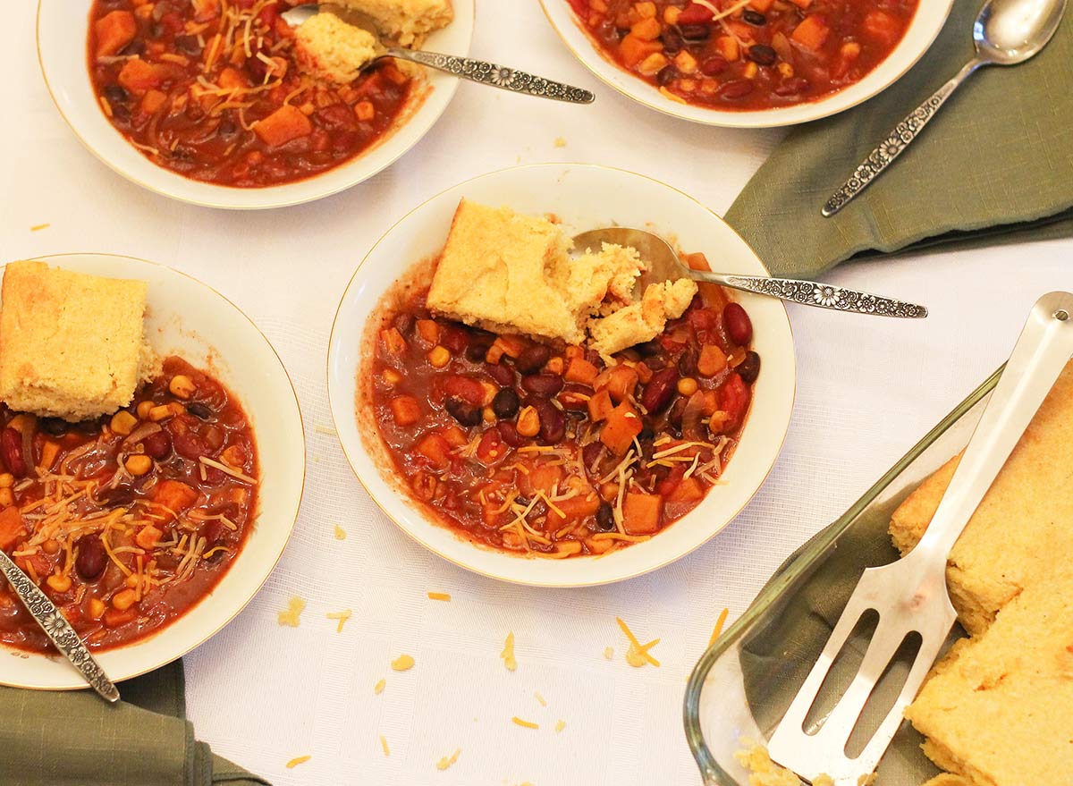 Crock pot vegetarian chili recipe with cheese and cornbread for the table